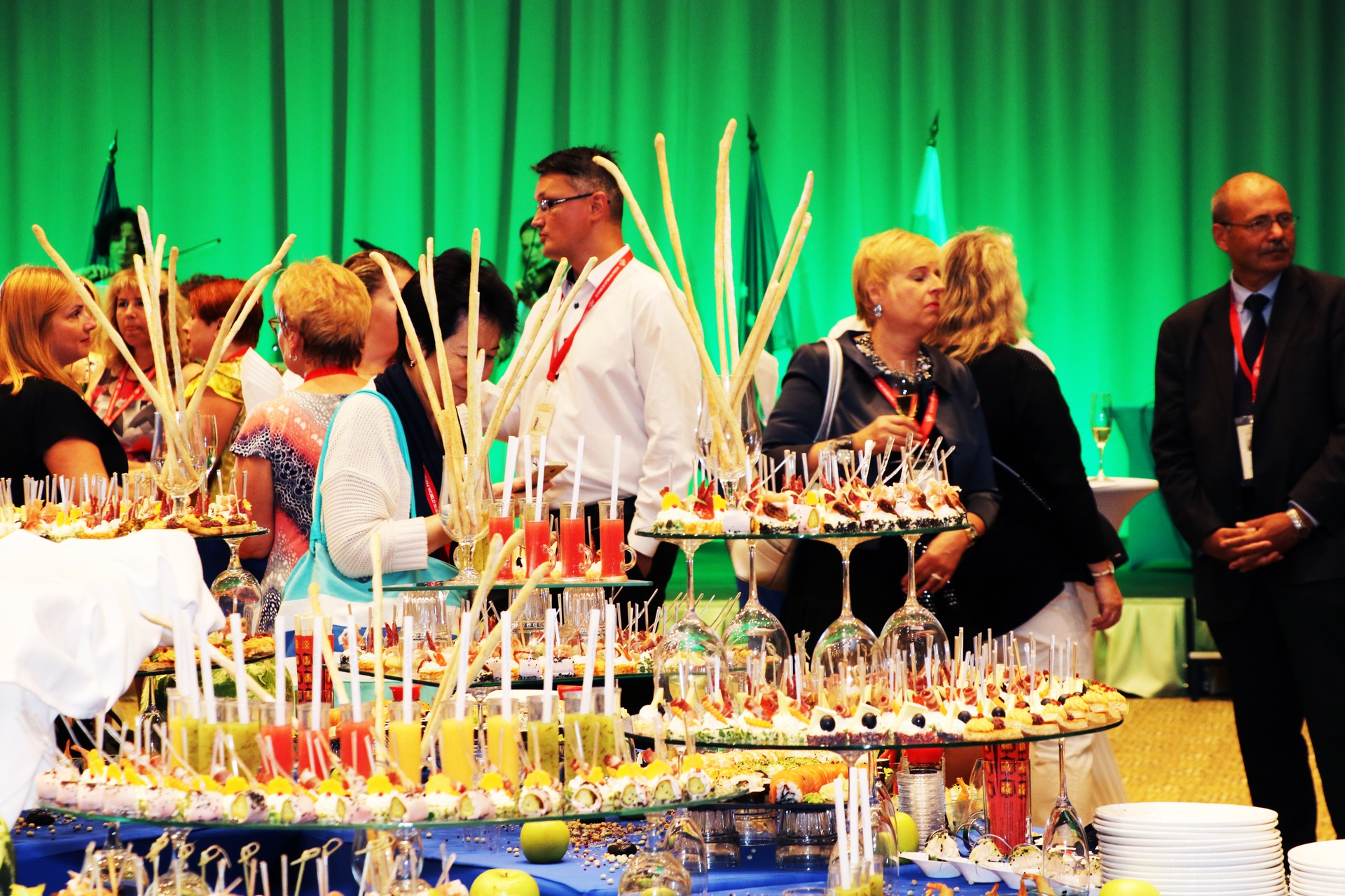 Guests gathered beside a conference buffet under green lighting