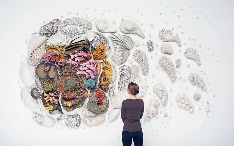 サンゴをモチーフにした壁面インスタレーションをじっくり見る来場者